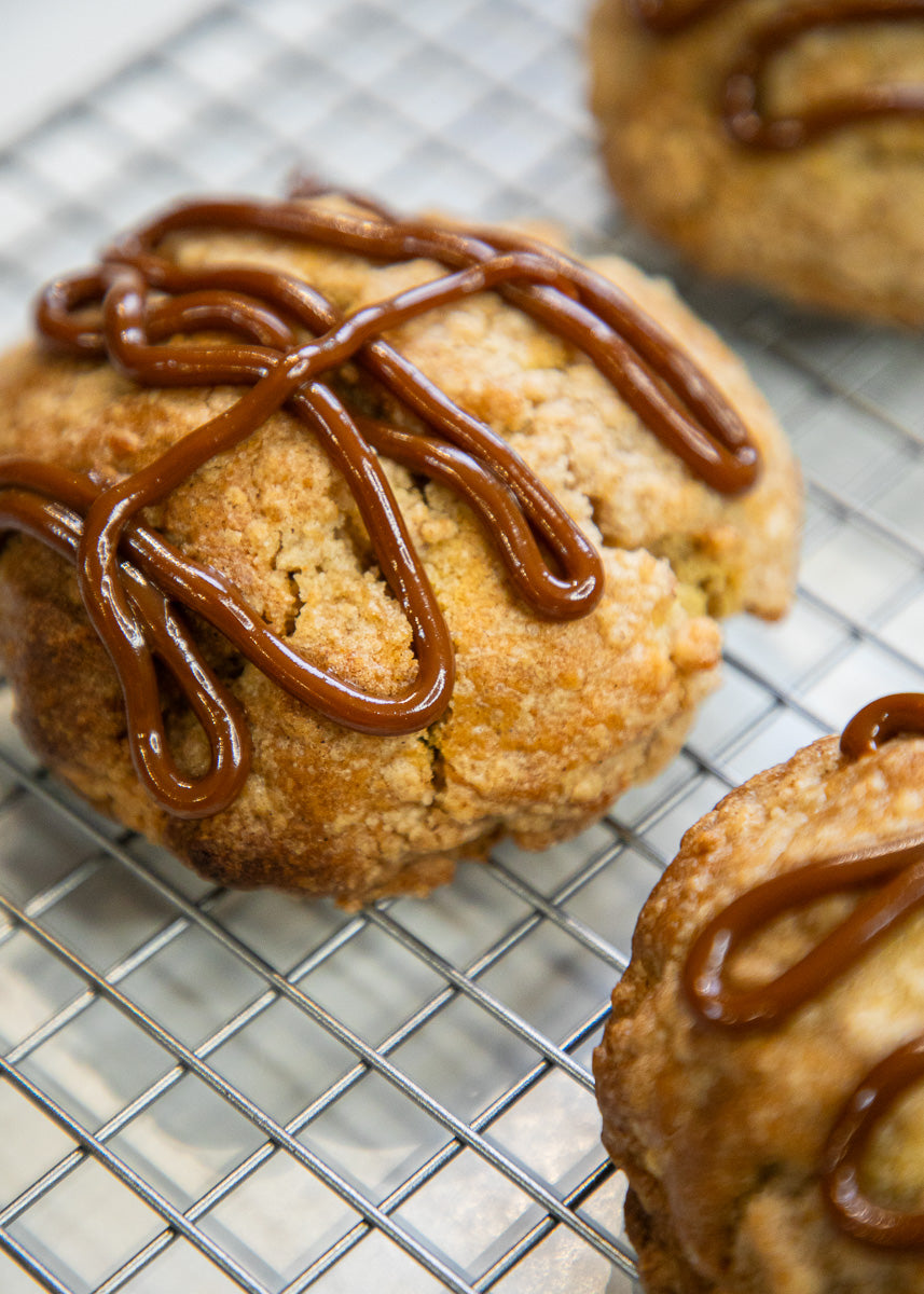 Cookies with dulce de leche drizzle on a cooling rack